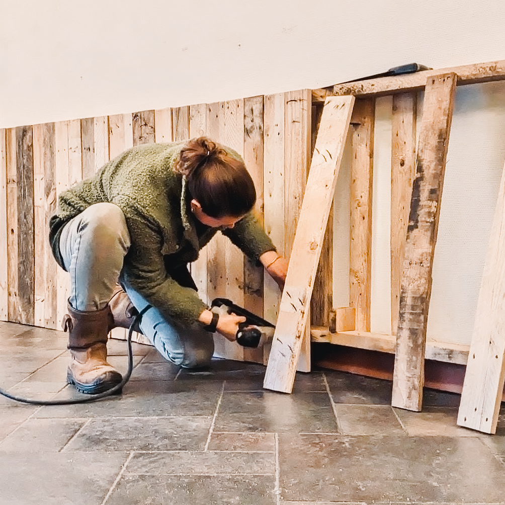 Renee building the pallet wall in the restaurant